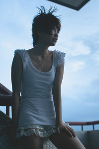 Portrait of a tall girl in a white dress looking at a distance.