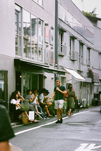 A caucasian man holding a takeaway coffee cup outside a cafe in Japan.