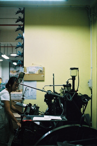 Michelle Yu testing prints on a letterpress machine.