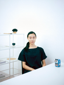 Portrait of a model wearing a Muji linen top with a pencil sharpener. The photograph is shot using analog film.