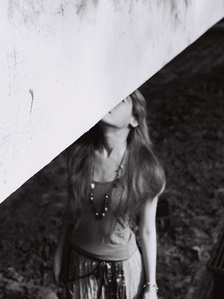 Abstract portrait of a girl under a bridge. The photograph is shot using black and white analog film.