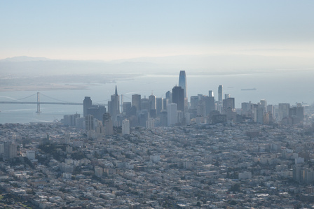 Helicopter aerial view of San Francisco's skyscrapers juxtaposed with low buildings.