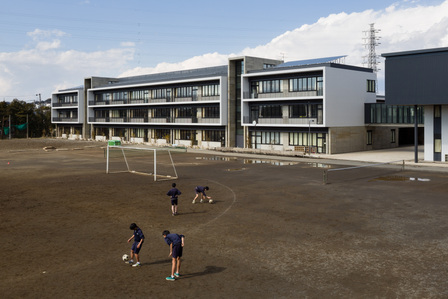 A group of boys playing soccer at the back of Ofuna Junior High School in Kamakura, Japan. It is designed by Ishimoto Architects.