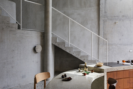 View of the curved kitchen counter in the House at Happy Avenue East by Linghao Architects.