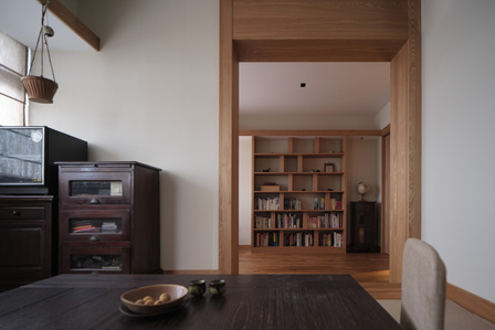 View from the interior of a Japanese-styled tea room looking out towards the study room bookshelves of an apartment in Toa Payoh designed by Goy Architects.