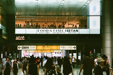 The glass facade of a Blue Bottle Coffee outlet in a crowded station in Japan.