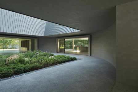 The curved wall of the courtyard of a house designed by Neri & Hu.
