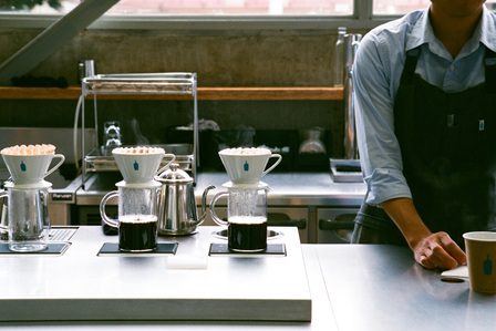 Glasses of coffee being prepared at the counter of Blue Bottle Coffee Japan.