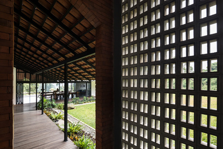 Precast concrete block wall of Sukasantai Farmstay in Indonesia designed by Goy Architects with cows in the background.