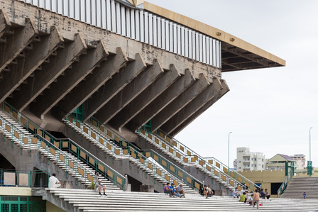 People sitting on the steps of the Indoor Stadium of the National Sports Complex designed by Vann Molyvann.