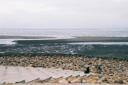 A boy and a girl staring into the ocean at Nanliao Fish Harbour in Hsinchu Taiwan.