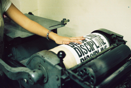 Text being printing using a letterpress machine.