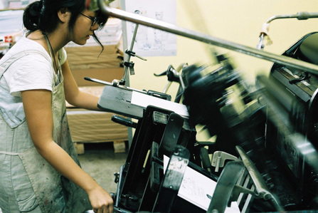 Michelle Yu working on a letterpress machine.