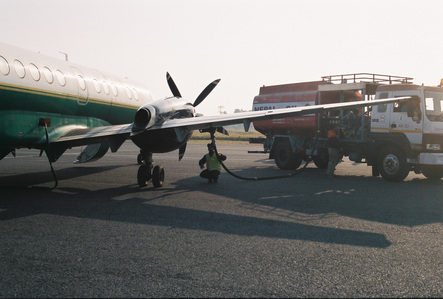 A man checking on a small plane in an airport in Nepal.