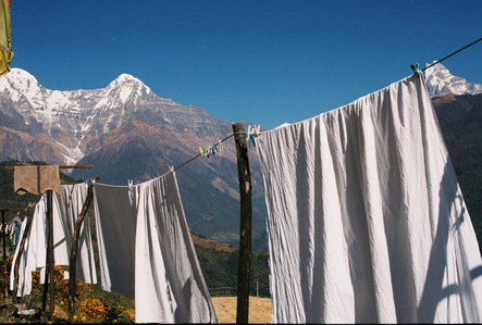 Clothes hanging dry under the sun with the Annapurna mountain range in the background.