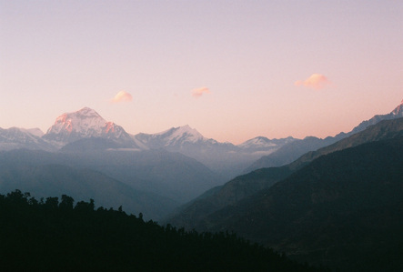 Three small pink clouds floating above the Annapurna mountain range in Nepal.