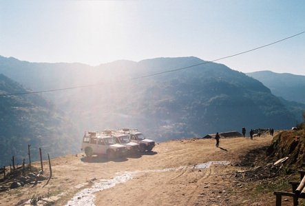 Cars parked at the edge of a cliff along a hiking trail in the Annapurna mountain of Nepal.