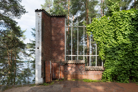 The roof tiles, steel fencing, and red bricks detail at Alvar Aalto Experimental House in Muuratsalo Finland.