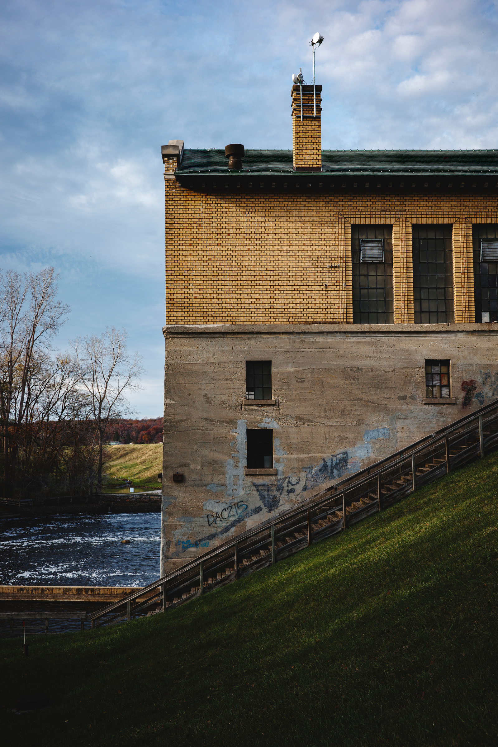 Explore the historic Barton Dam in Ann Arbor, Michigan, with this captivating photo showcasing its yellow brick architecture, weathered concrete walls, and surrounding natural beauty. Captured on a Ricoh GR camera, the image highlights the dam’s character
