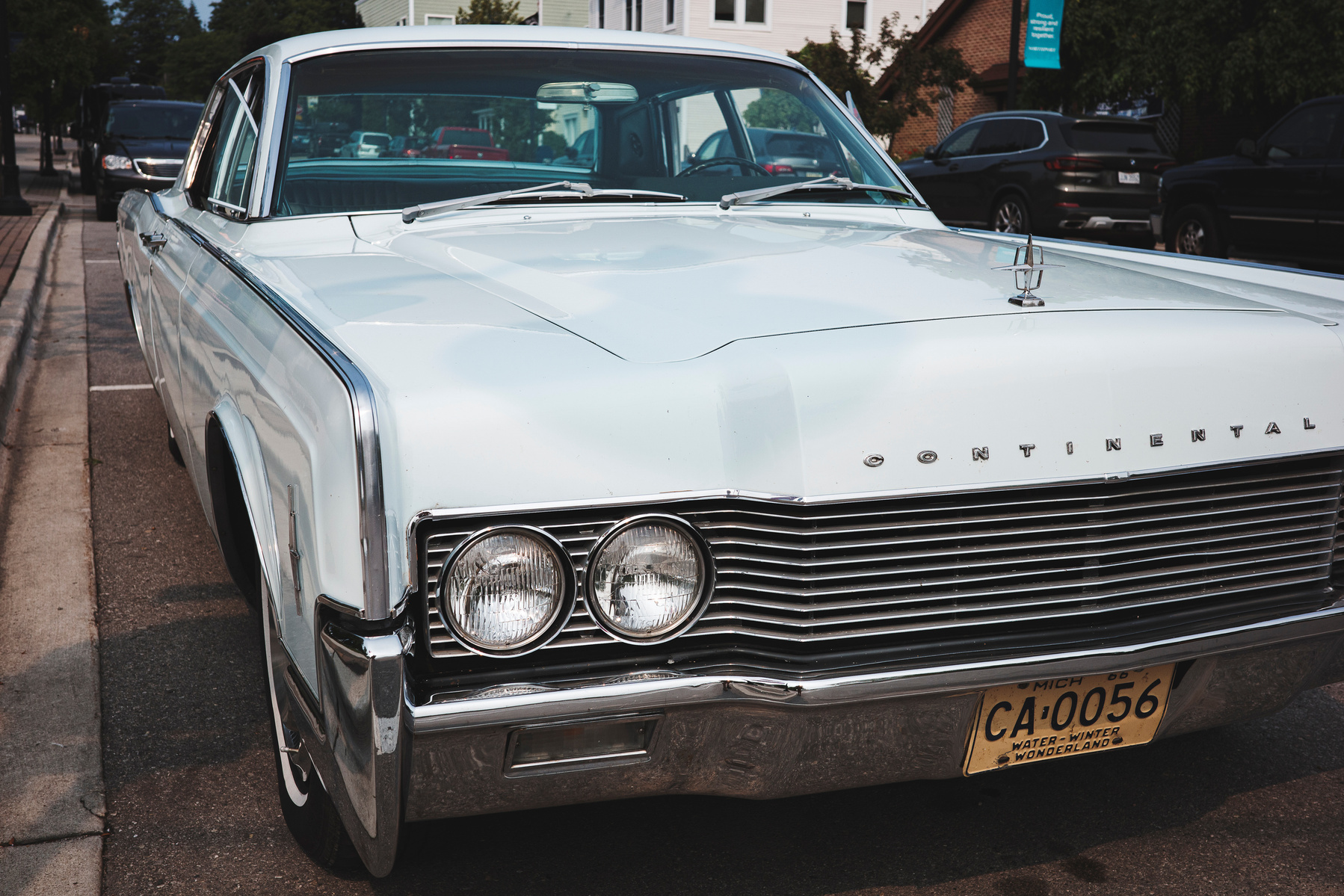 Admire the timeless elegance of a vintage Lincoln Continental on a Summer's day in Northport, Michigan. This crisp photo showcases the car’s sleek design and pristine condition, a highlight for automobile enthusiasts, fans of classic Americana. Ricoh GR