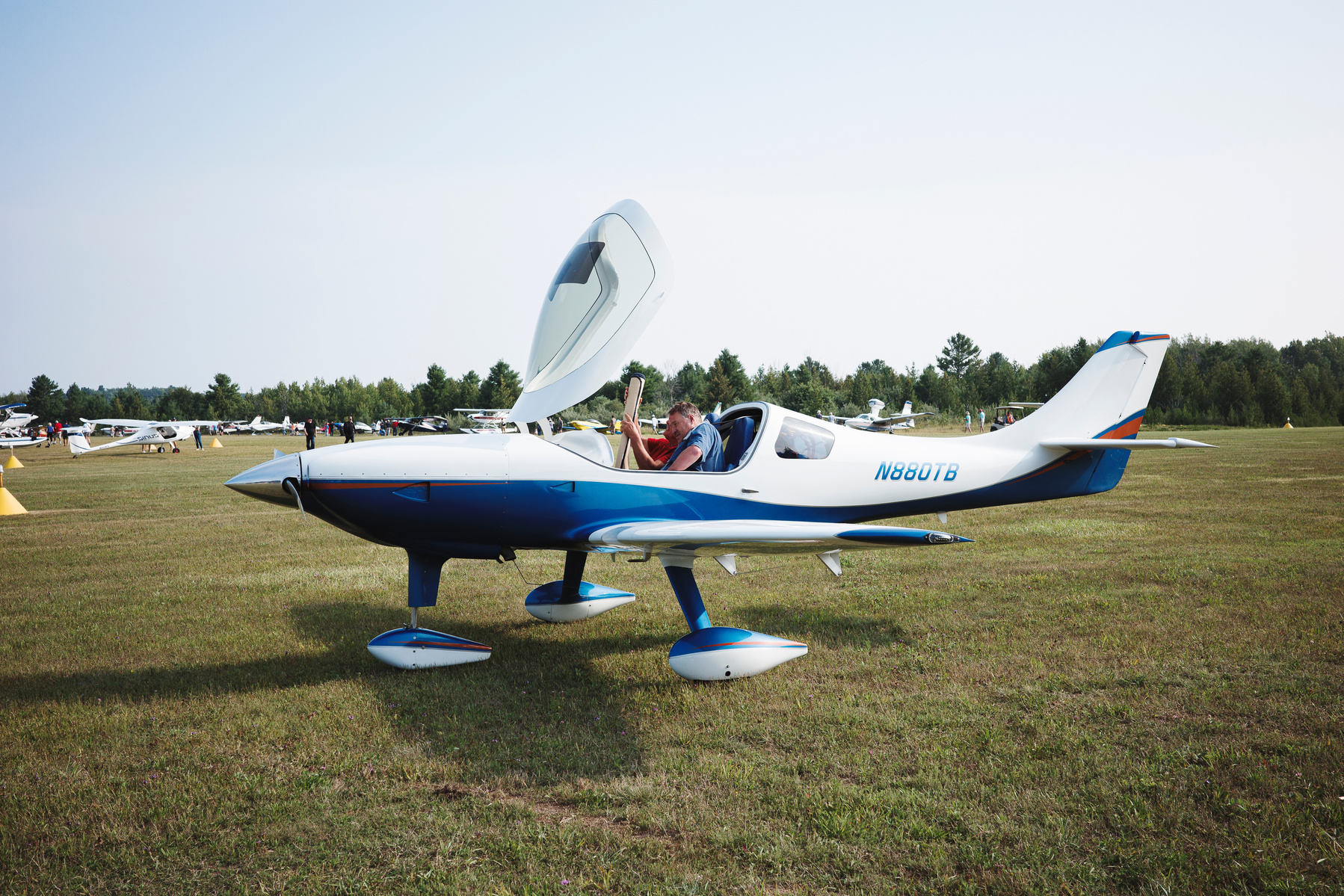 Experience the Woolsey Memorial Airport Fly-In in Northport, Michigan, with this photo featuring a sleek light aircraft parked on a grassy field. Captured at the popular annual aviation event, this image highlights the enthusiasm of pilots and aviation