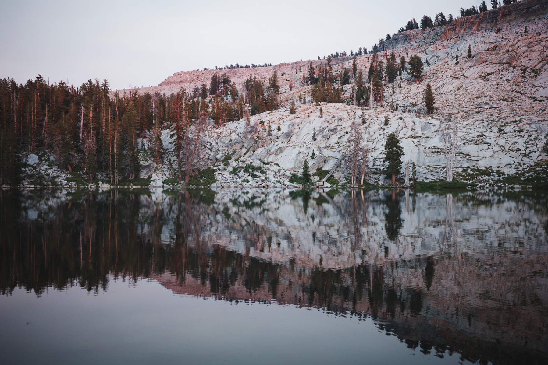 An evening shot of Ostrander Lake w/ alpenglow and the mountains reflected in still water; Yosemite National Park, California, USA. Ricoh GR IIIx in Yosemite National Park. July 2024.