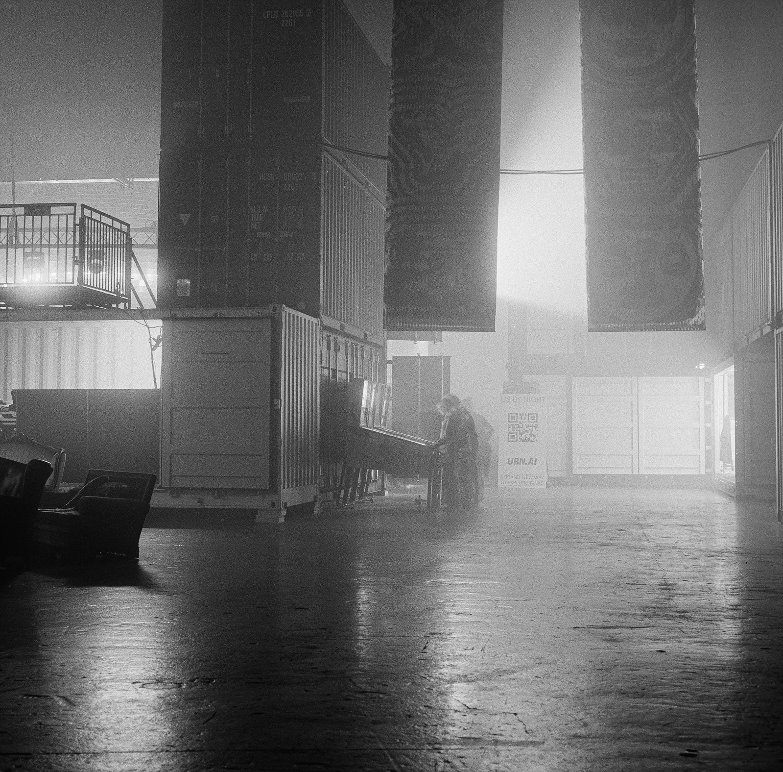 Black and white photo of a large hall with a distant pinball machine and haze. Shot on Hasselblad 500CM, Kodak Tri-X 400.