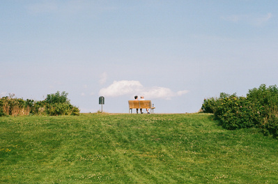 Analog photo of an old couple sitting on a bench with a view. Shot on Canon F1, Kodak Gold 200.