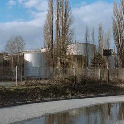 Industrial plant surrounded by trees without leaves in the winter. Shot on analog medium format Hasselblad 500CM, Portra 400.