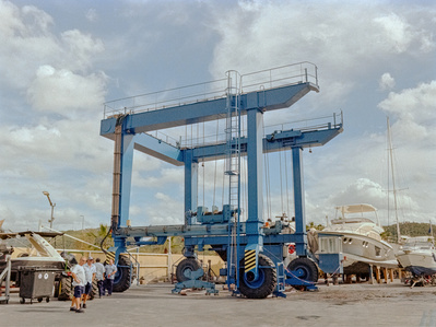 Large crane with workers and yachts at a marina on Mallorca, Spain. Shot on Hasselblad 500CM, Kodak Gold 200. 