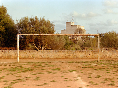 Abandoned sandy football pitch in front of an old building. Shot on analog medium format Hasselblad 500CM, Portra 400.