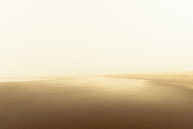 Warm foggy scene with distant people on the beach and diffuse light.