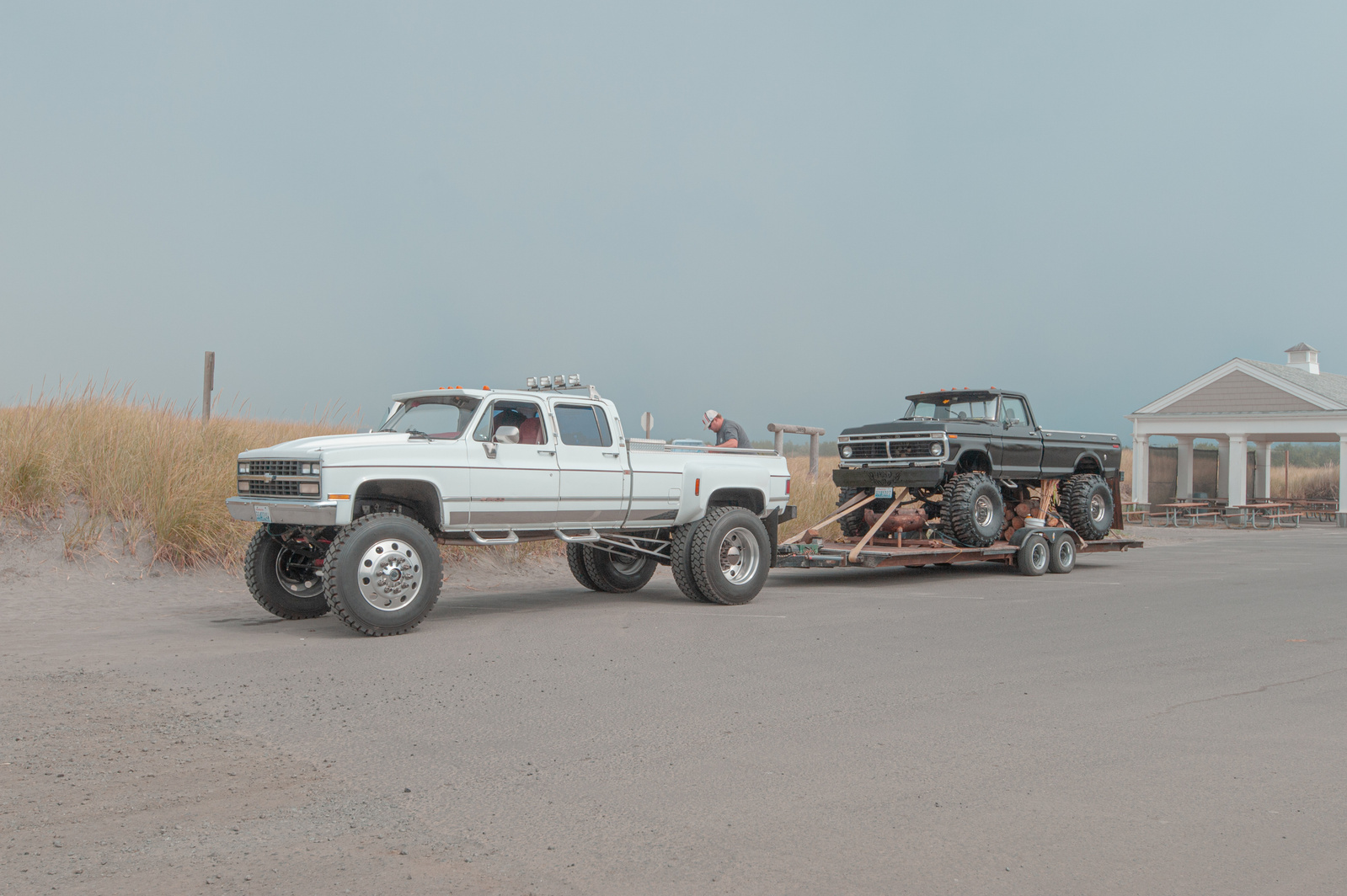 A monster truck towing another monster truck.