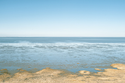Abstract coastal landscape photo with clear blue sky.