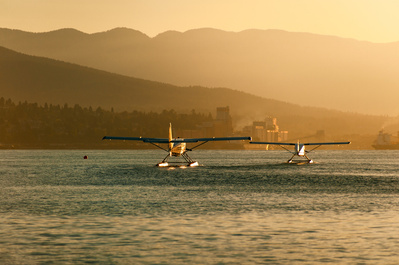 Landscape scene with two water planes in golden light at sunrise, Vancouver BC.