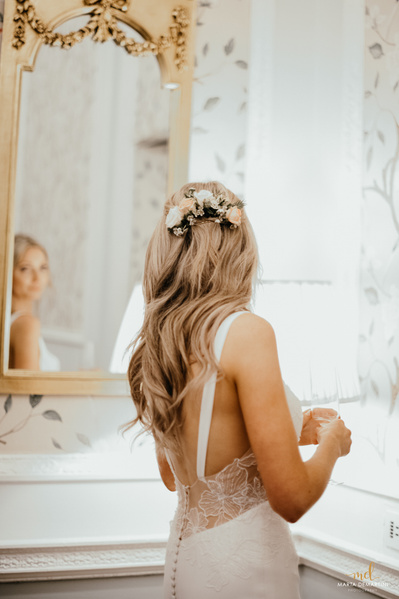 A bride looking in the mirror natural wedding hair and makeup 