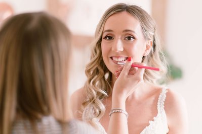 action shot with Evie applying lipstick to her Bride