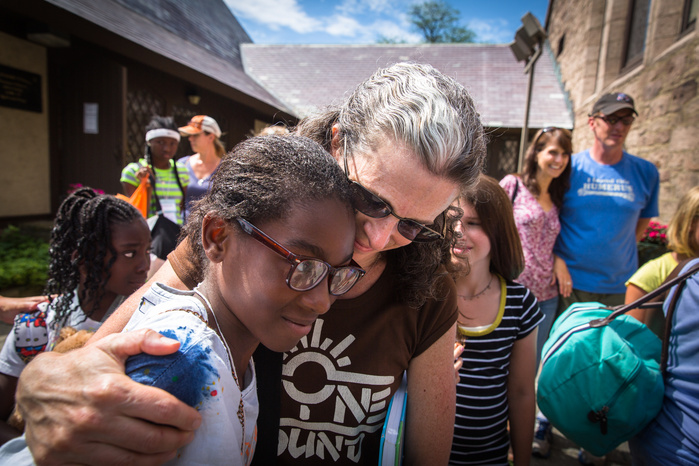 Jennifer Martin embraces Brianna George, 11, of Fort Greene, Brooklyn, before she boards a bus from St. James Episcopal Church in Greenfield to travel back home at the end of her week with the Martins, Friday, July 15. Brianna spent a week with the Martin