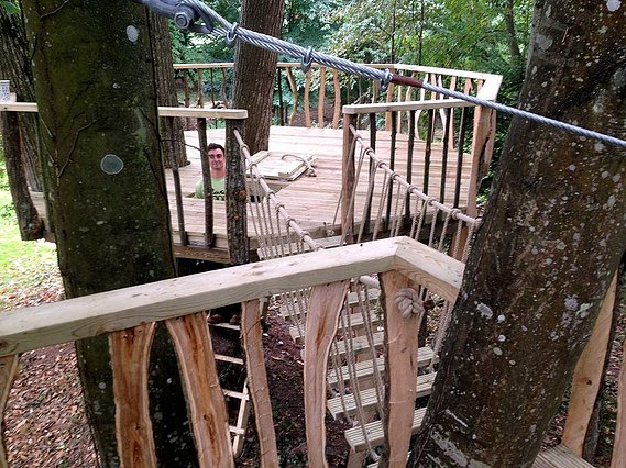 a ladder-accessed large octagonal decked platform that has sufficient space in order to build a concealed tree house within the circumference to allow for a balcony surround