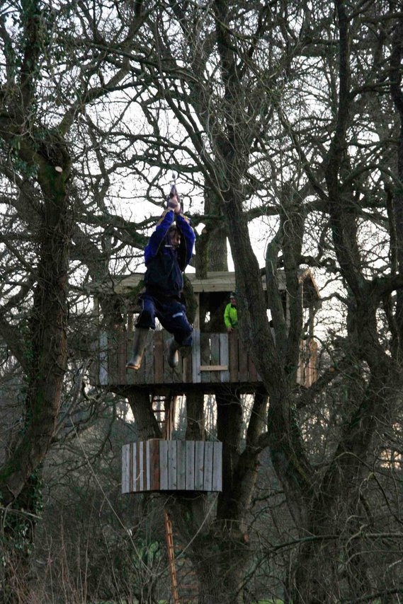 Boy riding a zipwire from a treehouse