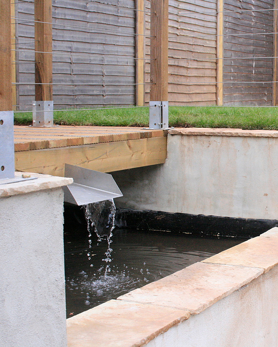 A contemporary area centered around a water feature, garden landscaping Devon