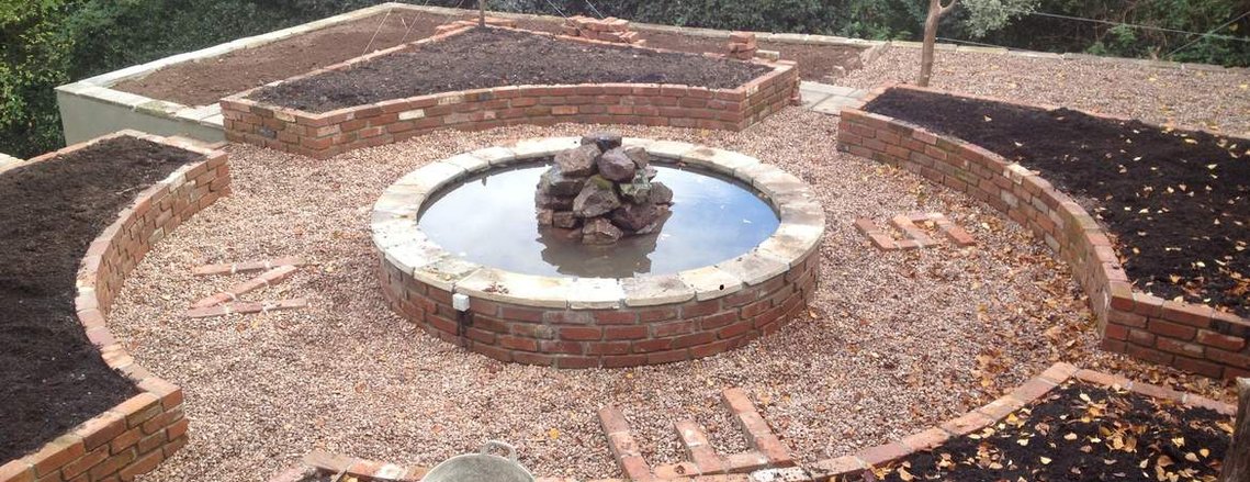 Garden landscaping incorporating a compass design with water feature in Devon