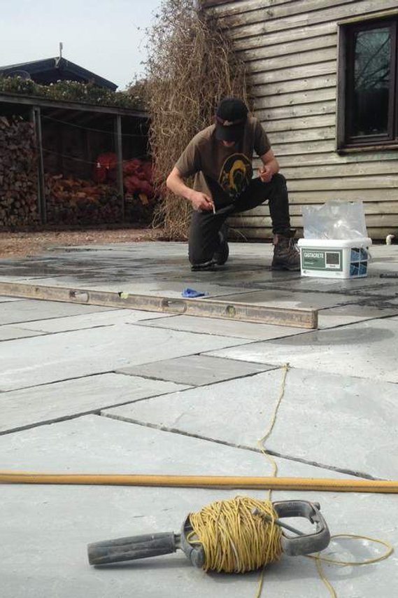 using a plumb line and level to lay stone paving