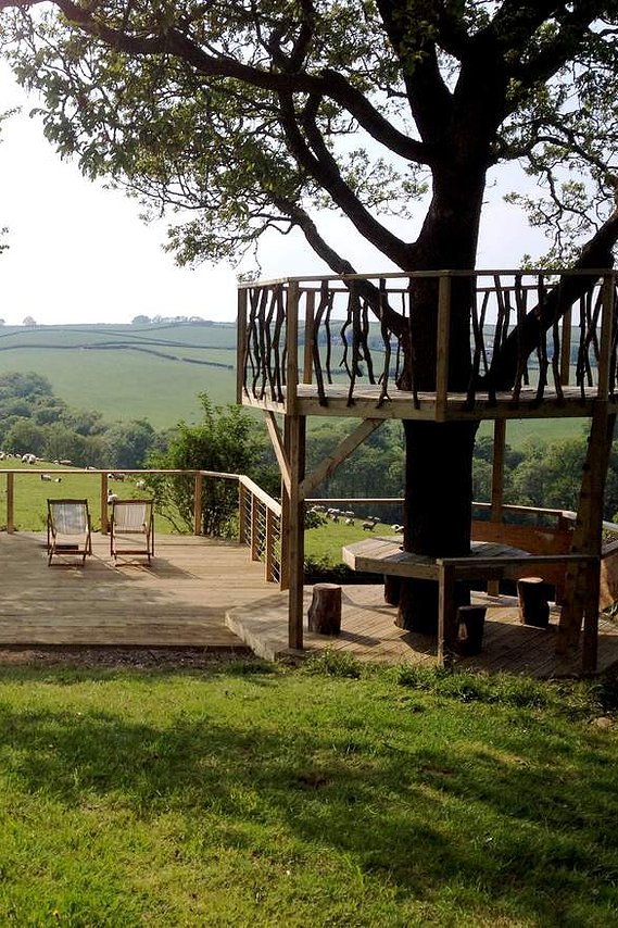 decked platform going into the playground area, with slide & climbing wall, overlooking the Devon countryside
