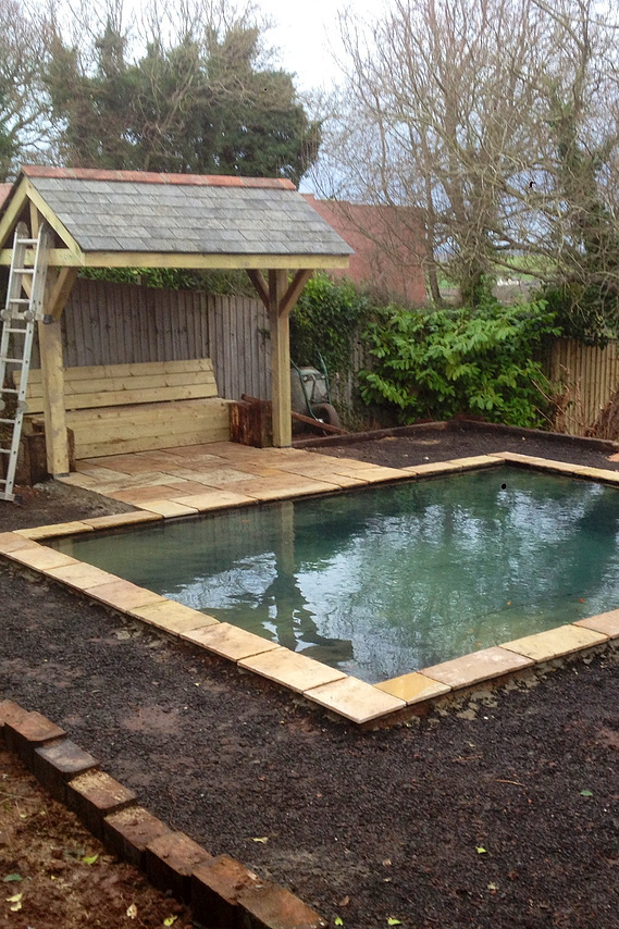 Garden landscaping in Devon, a hoggin path surrounds a water feature, a seated area uses reclaimed roofing slates. Seriously Good Landscapes, Devon