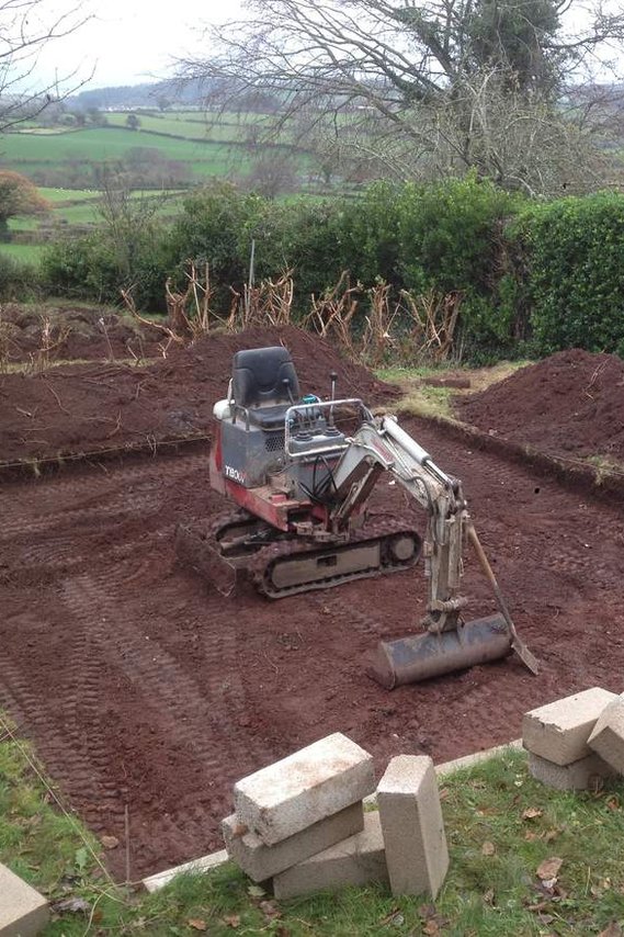 digger working on a Moretonhampstead landscaping project, nature/wildlife pond surrounded by hogging path