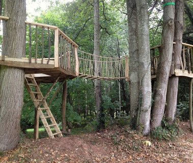 turret accessed via a 'wobbly bridge' with a 40 metre zipwire into the surrounding woodland and a landing pad of woodchip