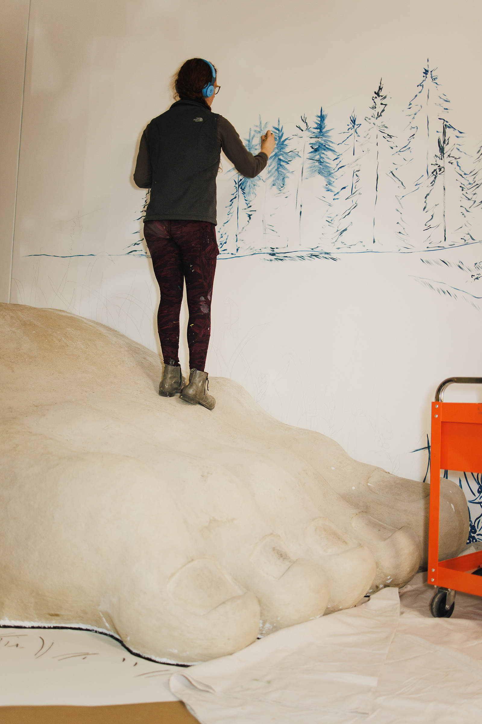 KANSAS CITY, MO – DECEMBER 07, 2023: Kelli Harrod paints a scene from “One Morning in Maine” by Robert McCloskey on a wall at The Rabbit Hole; an immersive museum in Kansas City, MO where people can experience scenes and characters from children’s literat