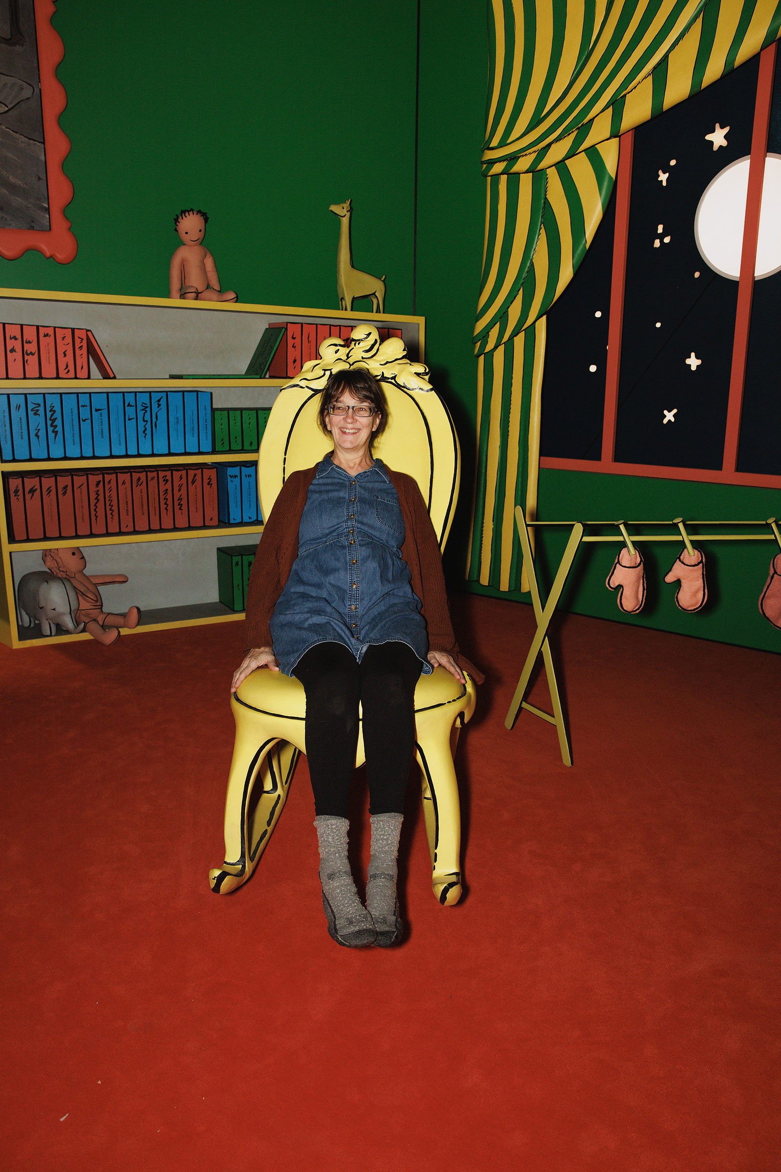 KANSAS CITY, MO – DECEMBER 07, 2023: Rabbit Hole cofounder Debbie Pettid on a chair in the “Goodnight Moon” exhibit at The Rabbit Hole; an immersive museum in Kansas City, MO where people can experience scenes and characters from children’s literature. Cr