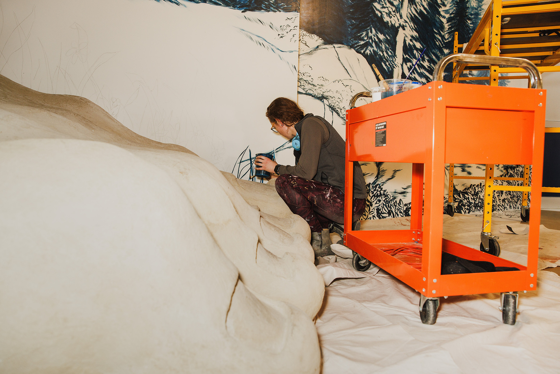 KANSAS CITY, MO – DECEMBER 07, 2023: Kelli Harrod paints a scene from “One Morning in Maine” by Robert McCloskey on a wall at The Rabbit Hole; an immersive museum in Kansas City, MO where people can experience scenes and characters from children’s literat